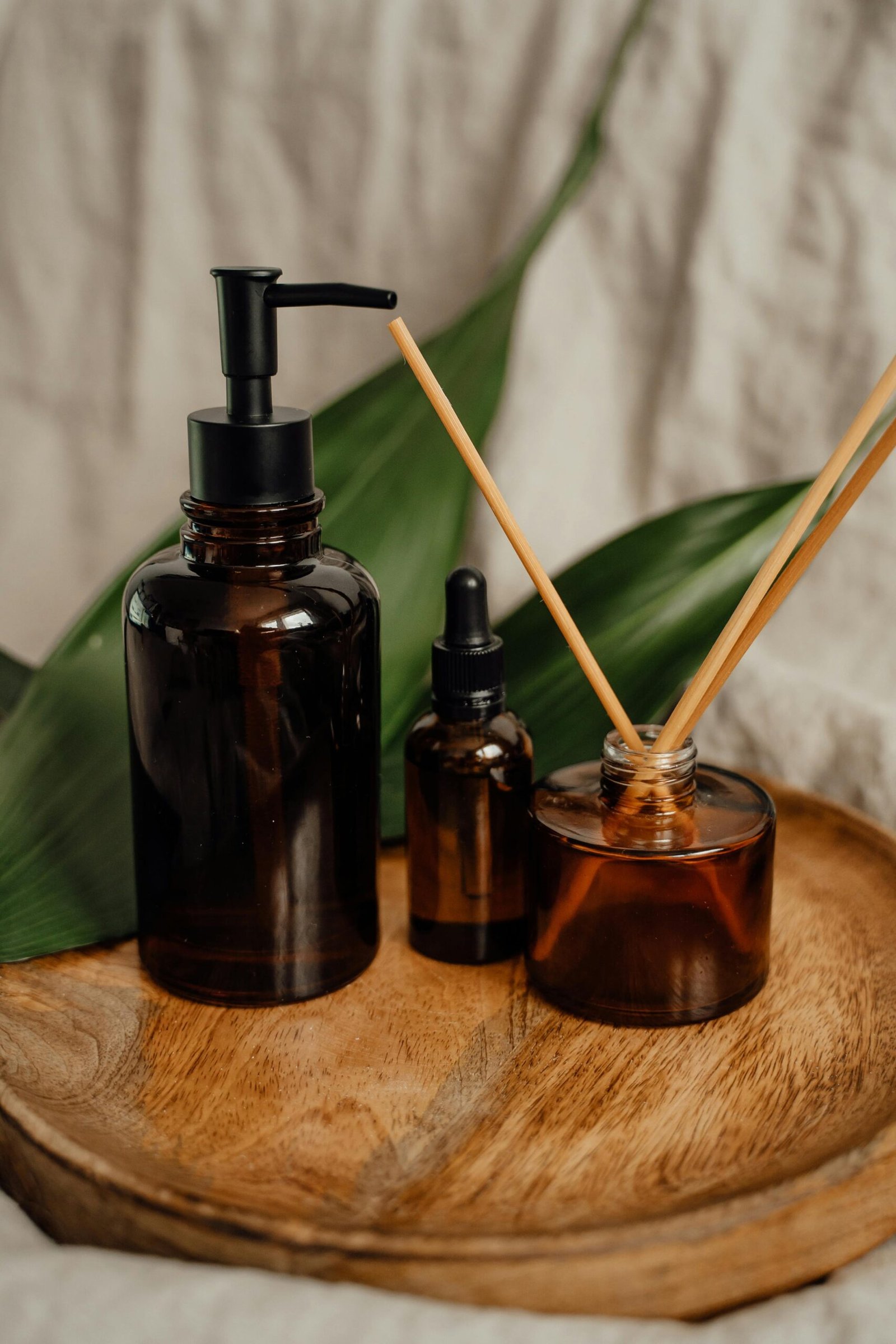 A stylish setup of amber glass diffuser and bottles on a wooden tray, perfect for aromatherapy enthusiasts.